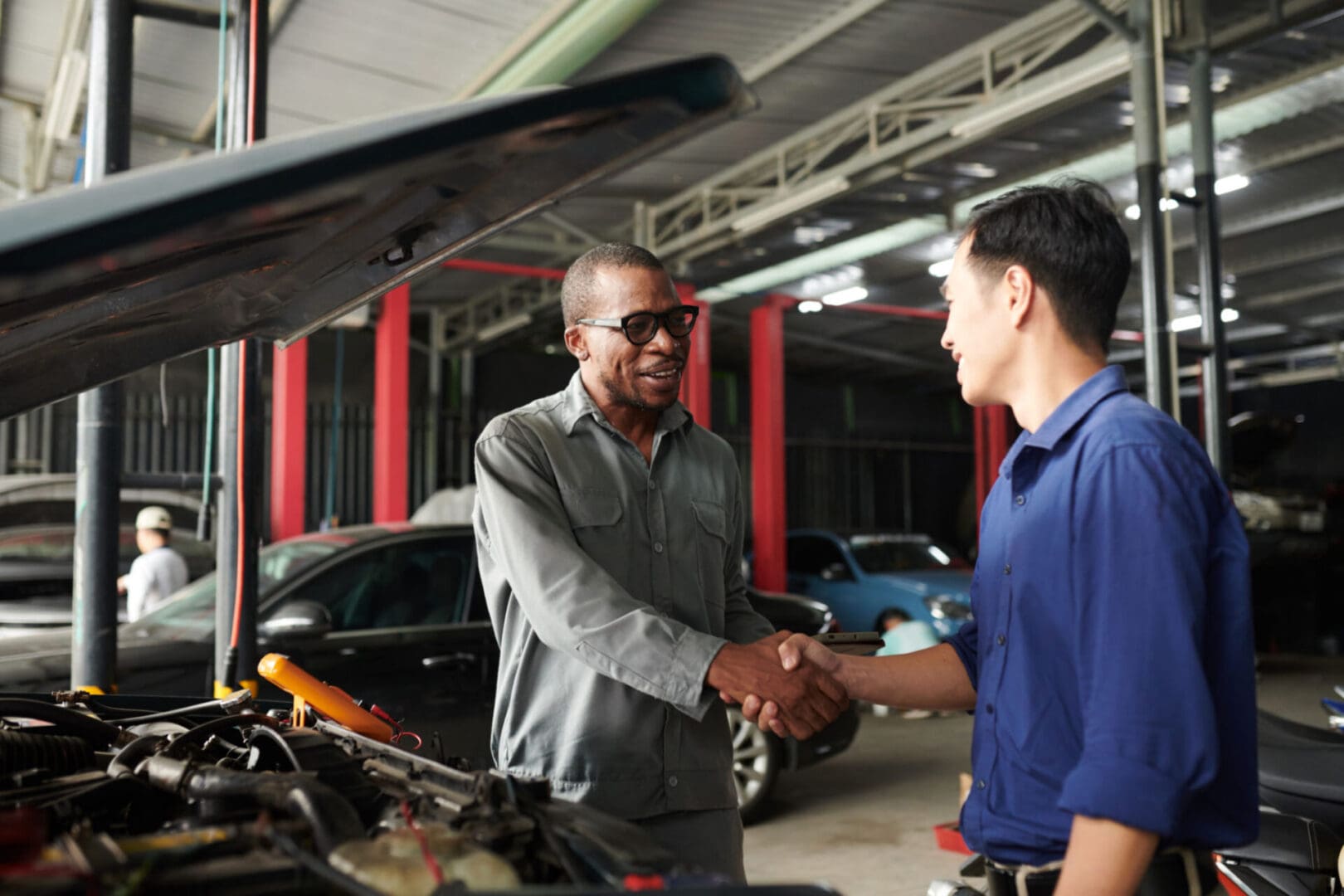 Mechanics shaking hands in garage
