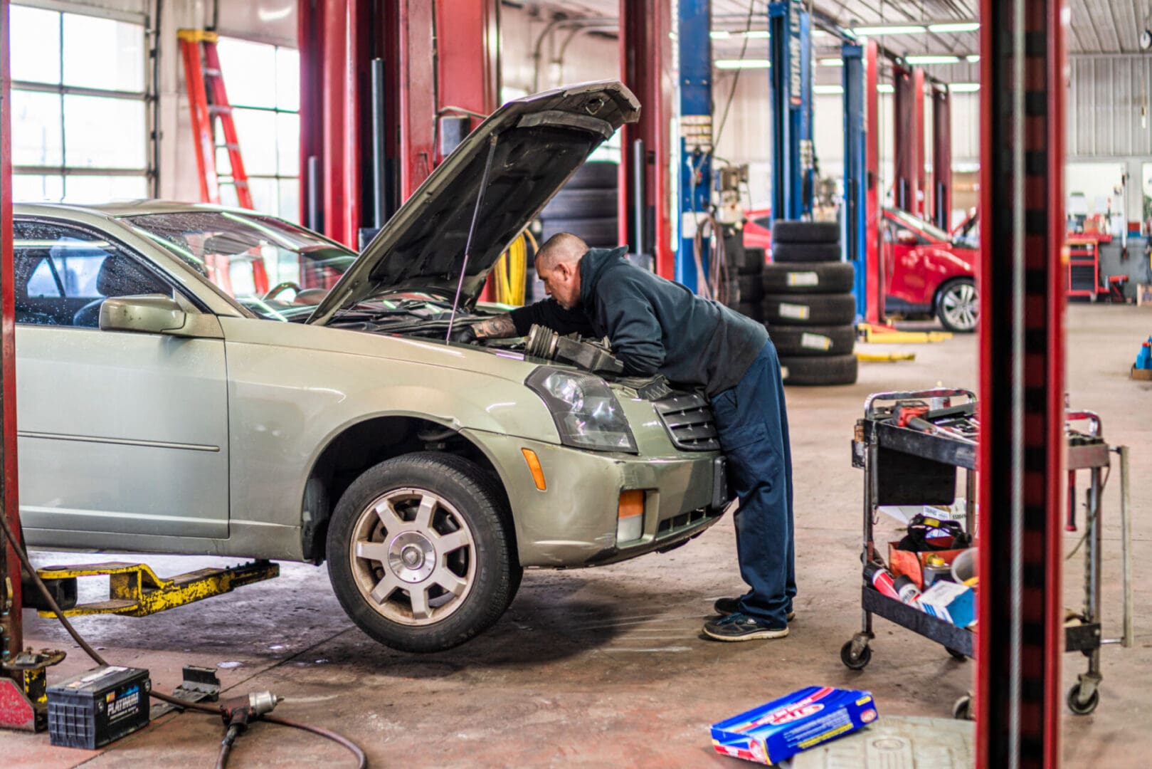 Mechanic inspecting car engine in garage