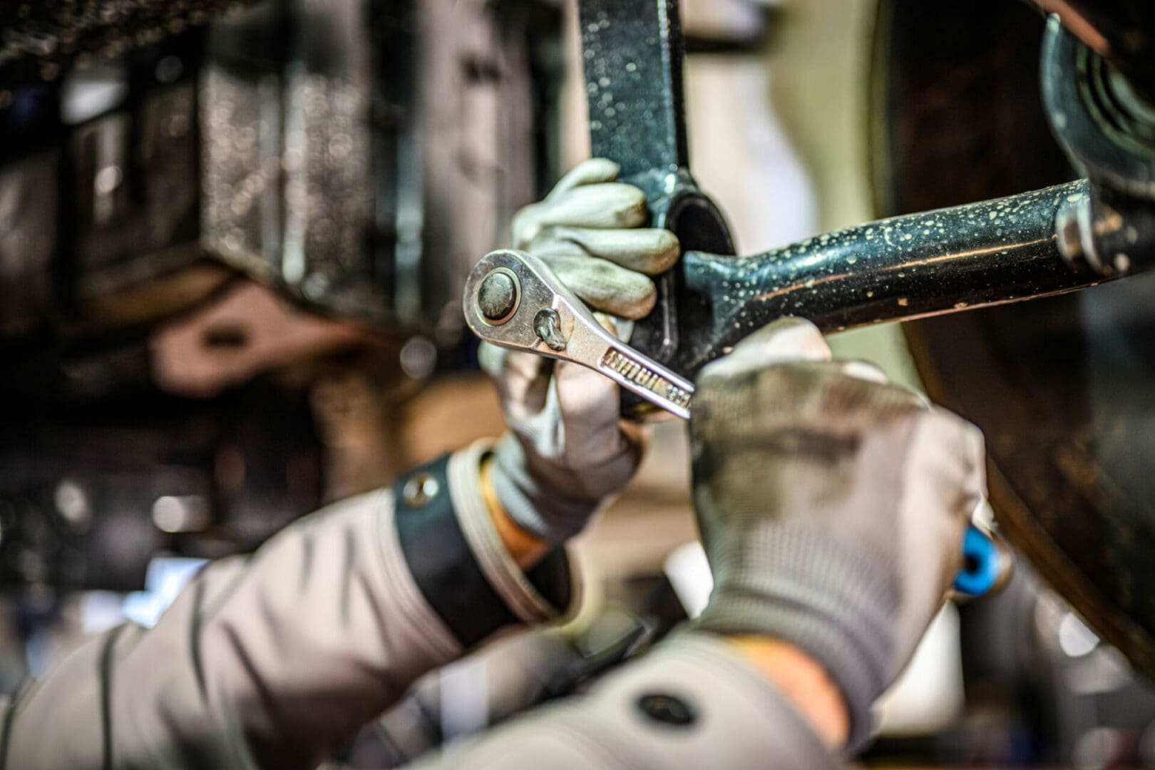 Hands repairing vehicle undercarriage