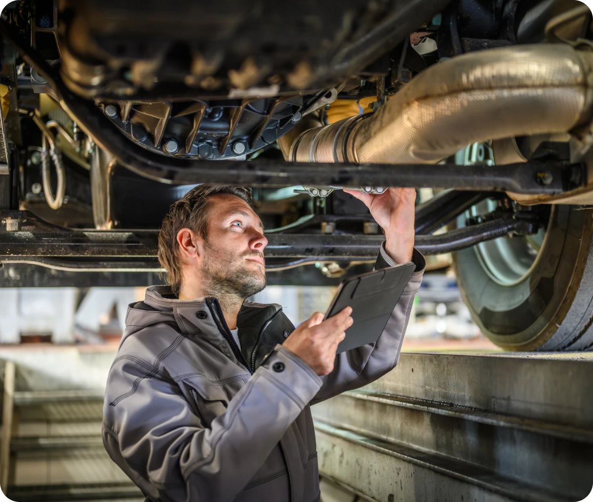 Technician examining car underside